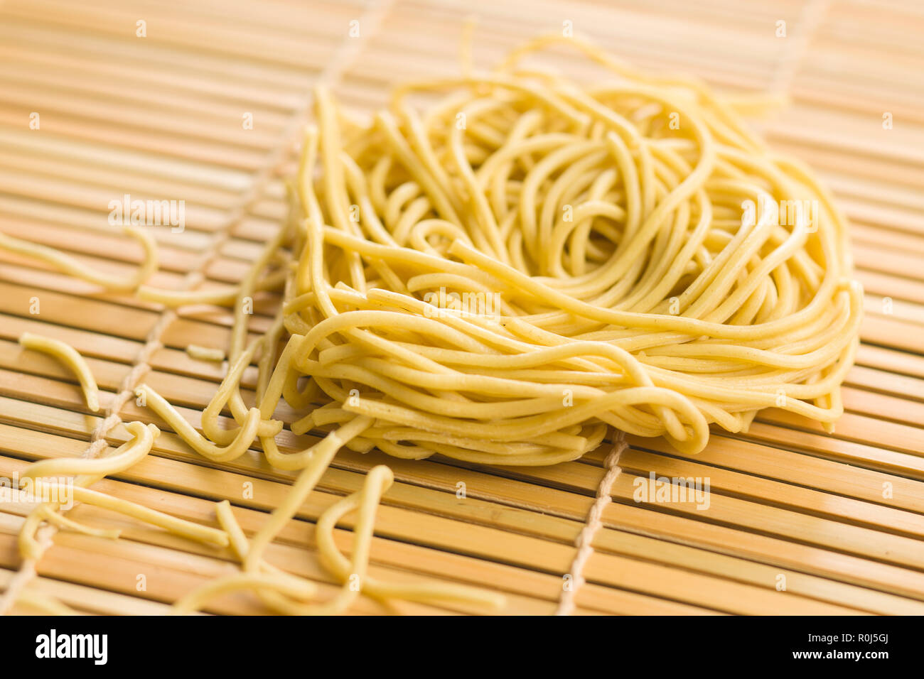 Uncooked instant chinese noodles on bamboo napkin. Stock Photo