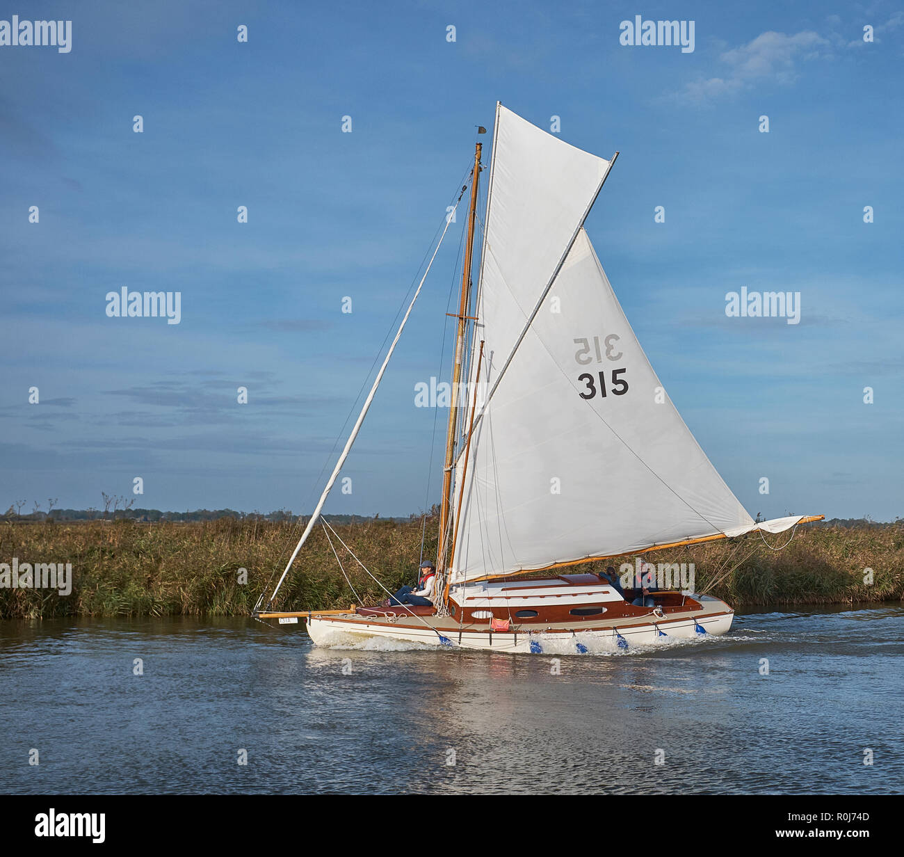 A Fractional Sloop sailing boat with white sails on the River Thurne