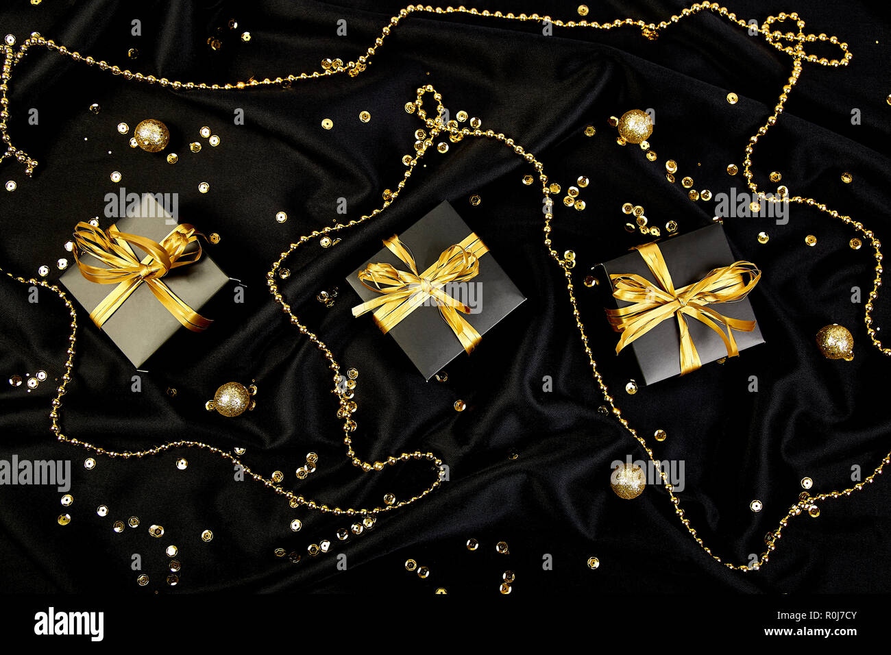 Luxury black gift boxes with gold ribbon on shine background. Christmas ...