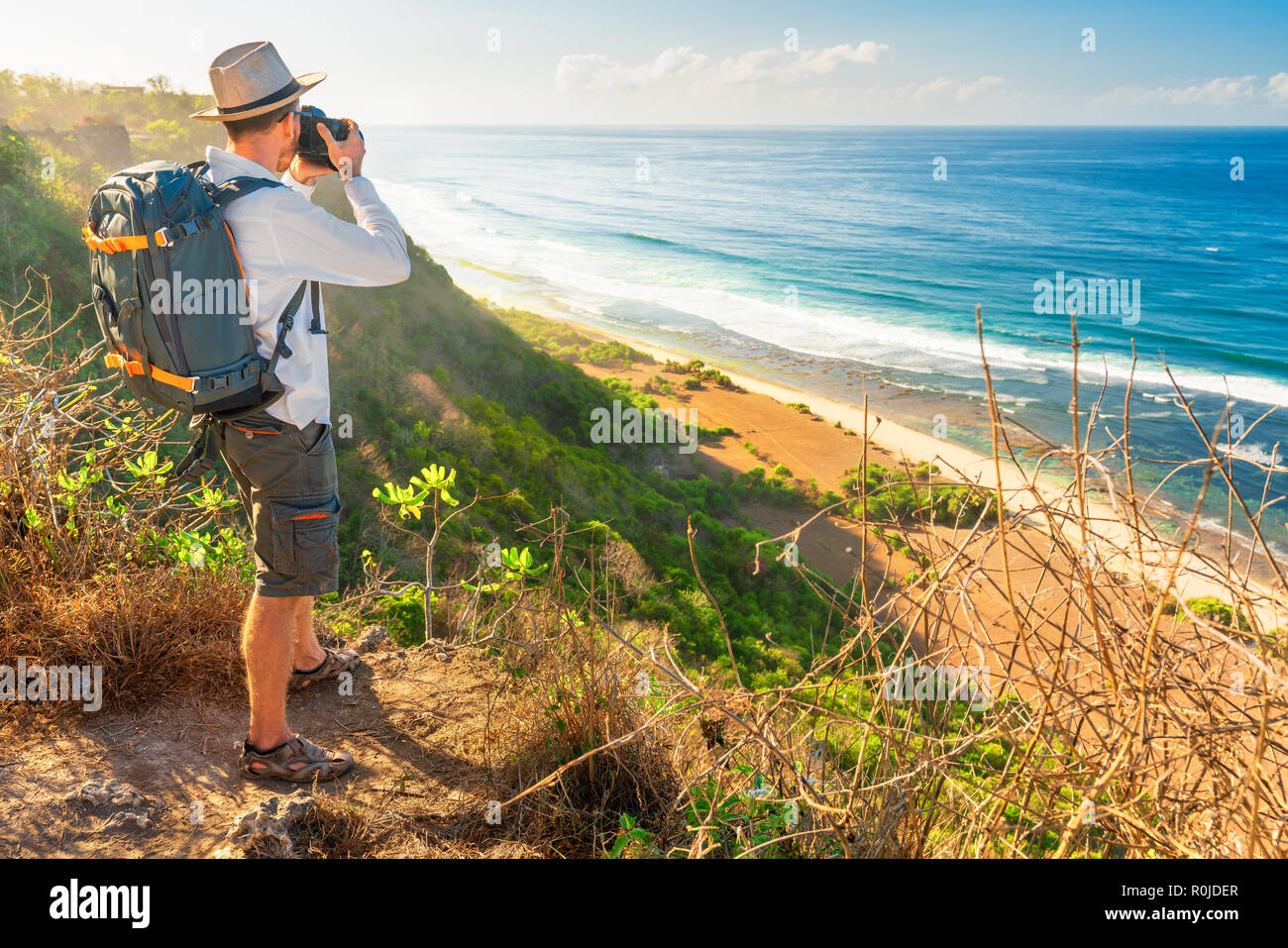 Young backpacker traveling along mountains, happy travel man explore island to Bali, discovering world, summer vacation concept Stock Photo