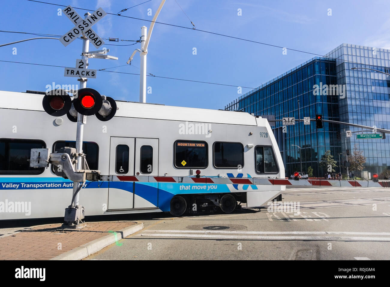 November 2, 2018 Sunnyvale / CA / USA - Waiting at a barrier for a VTA Train to pass in south San Francisco bay; VTA Light Rail is a system serving Sa Stock Photo