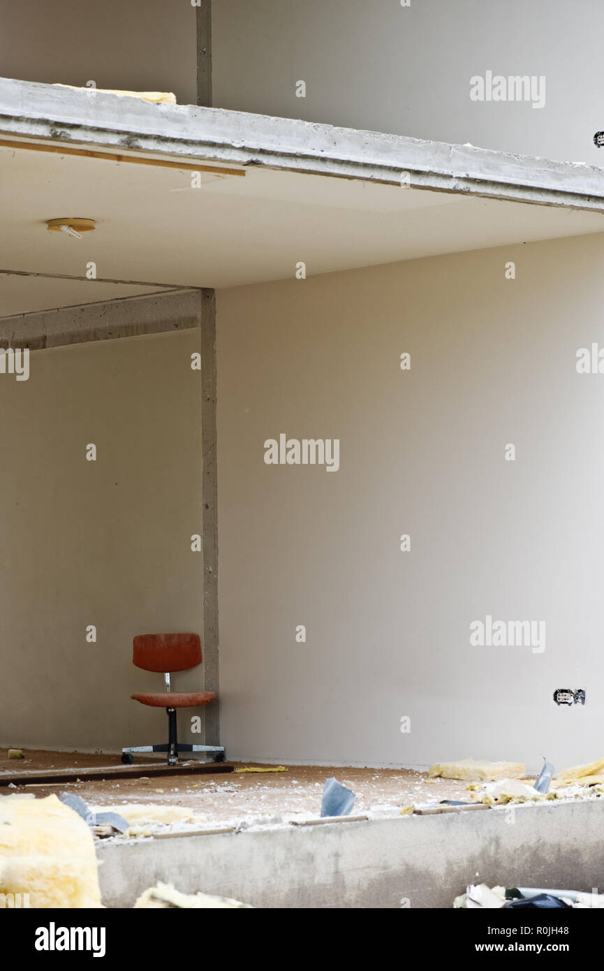 Office chair inside partially demolished building. Stock Photo