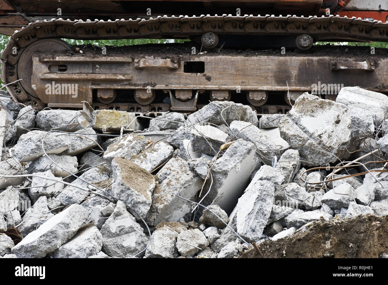 Heavy construction machine above pile of broken concrete at a building demolition site. Stock Photo