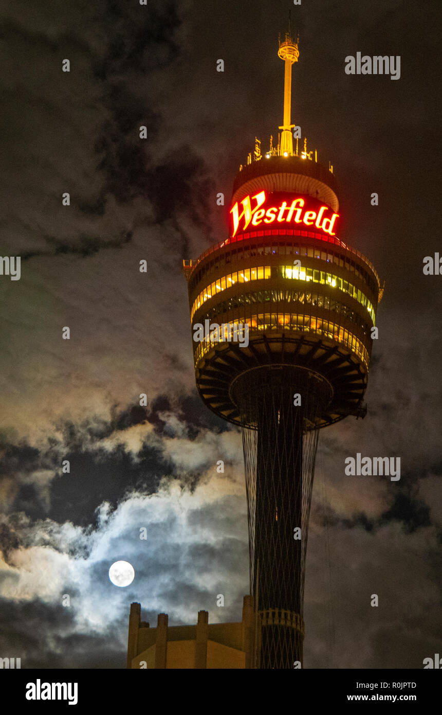 The Sydney Tower lit up at night with a full moon in the evening sky Sydney NSW Australia. Stock Photo