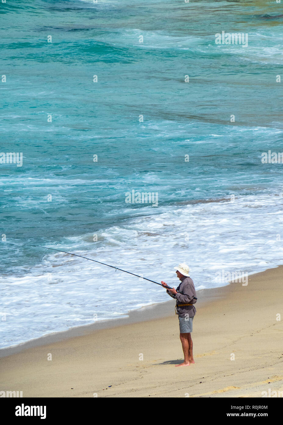 Lone male fisherman fishing with a fishing rod from the sandy Bronte Beach Sydney  NSW Australia Stock Photo - Alamy