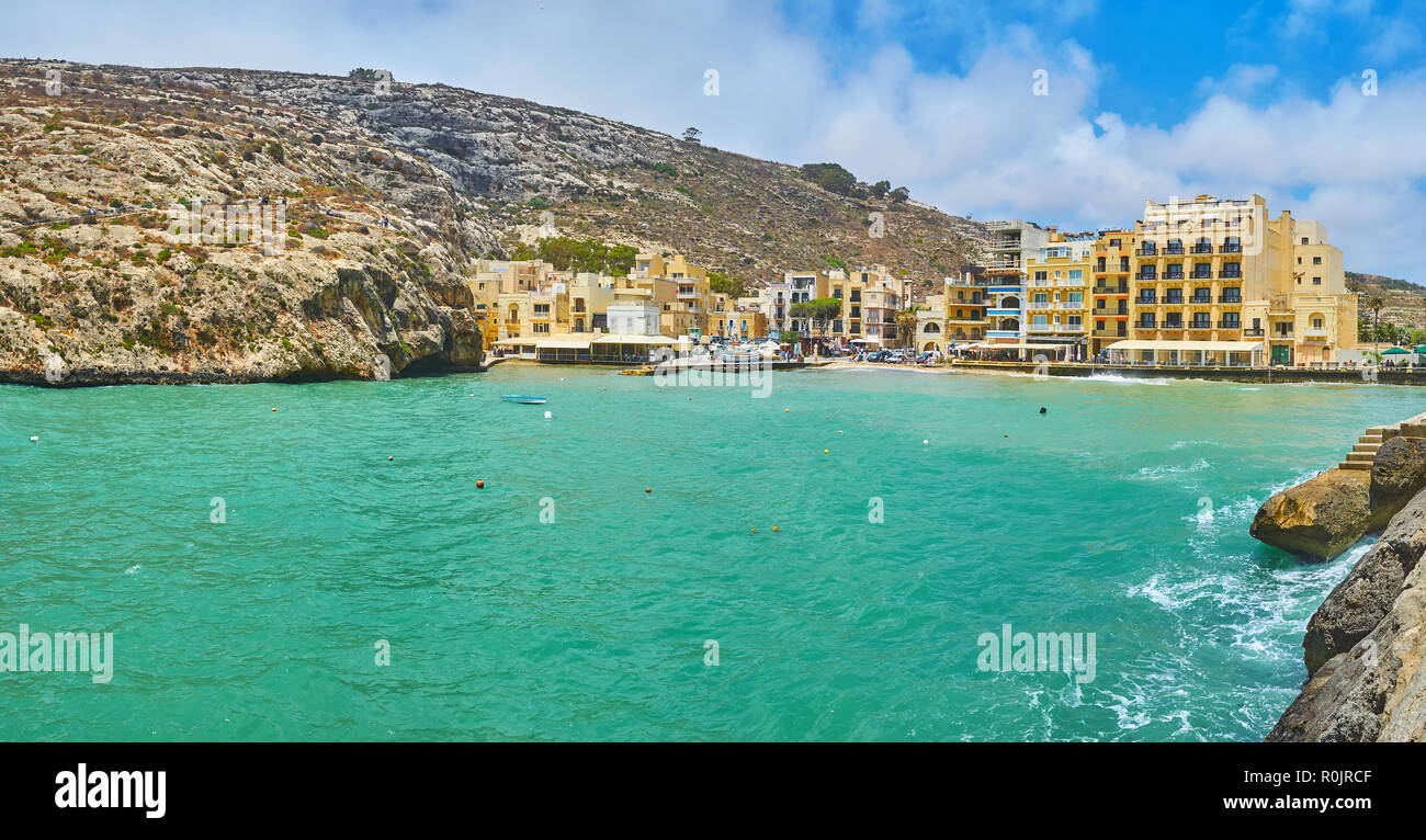 The narrow harbour of Xlendi village with boats, bobbing on stormy