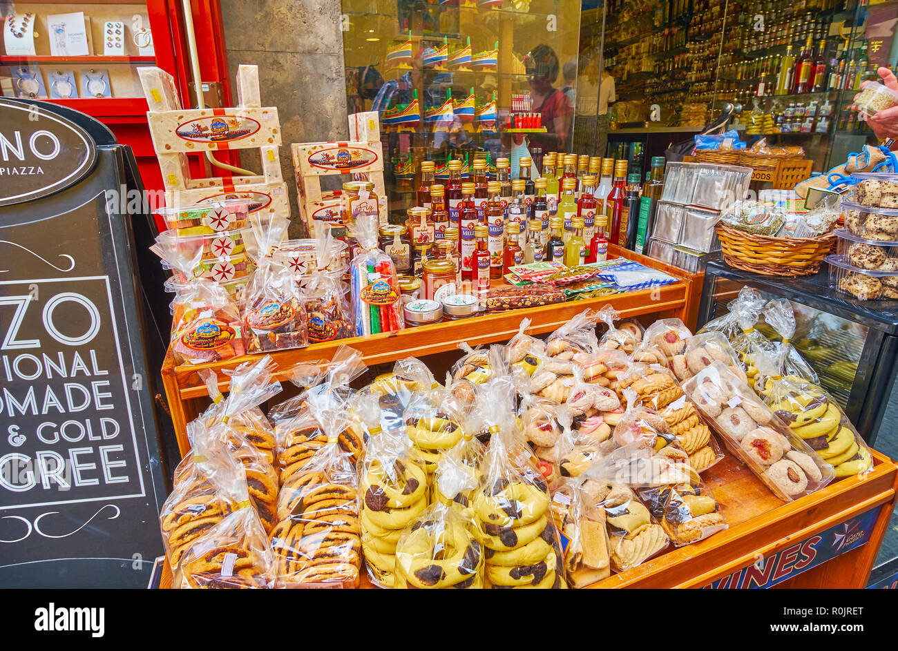VICTORIA, MALTA - JUNE 15, 2018: The wide range of tasty souvenirs from Gozo Island - cookies, jam, local gbejna cheese, liquors and sweets on the tab Stock Photo