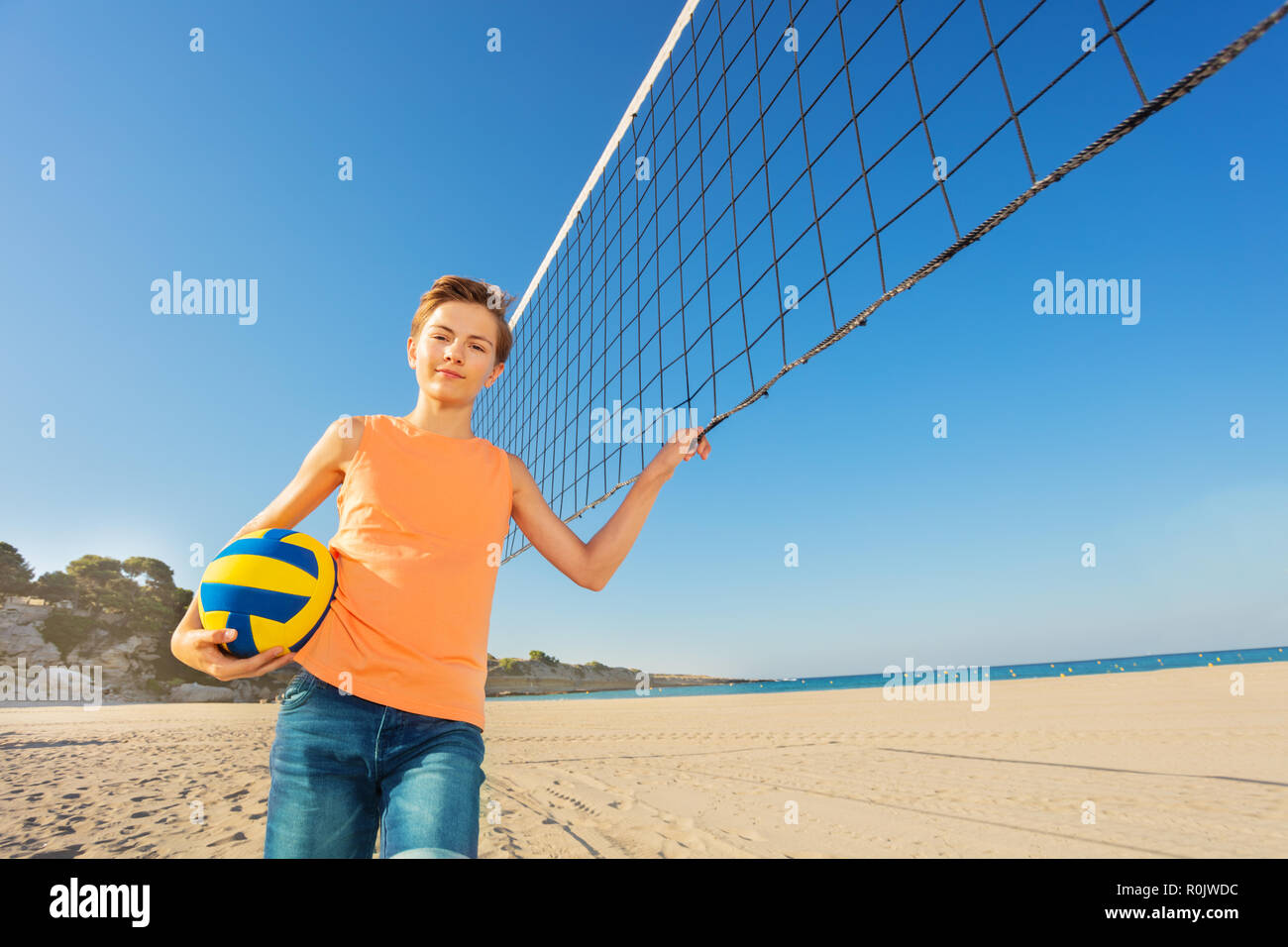 Teen boy getting ready for beach volleyball game Stock Photo Alamy