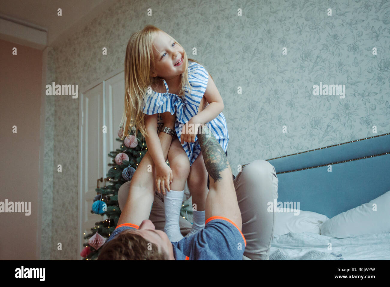 dad playing with little girl on bed at home Stock Photo