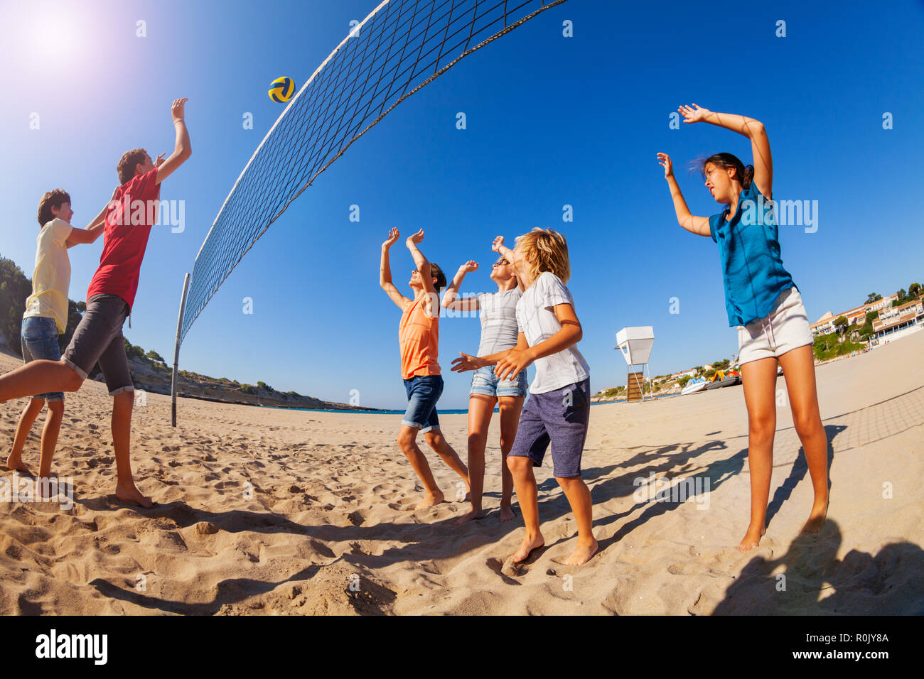 Boy passing volleyball during game on the beach Stock Photo Alamy
