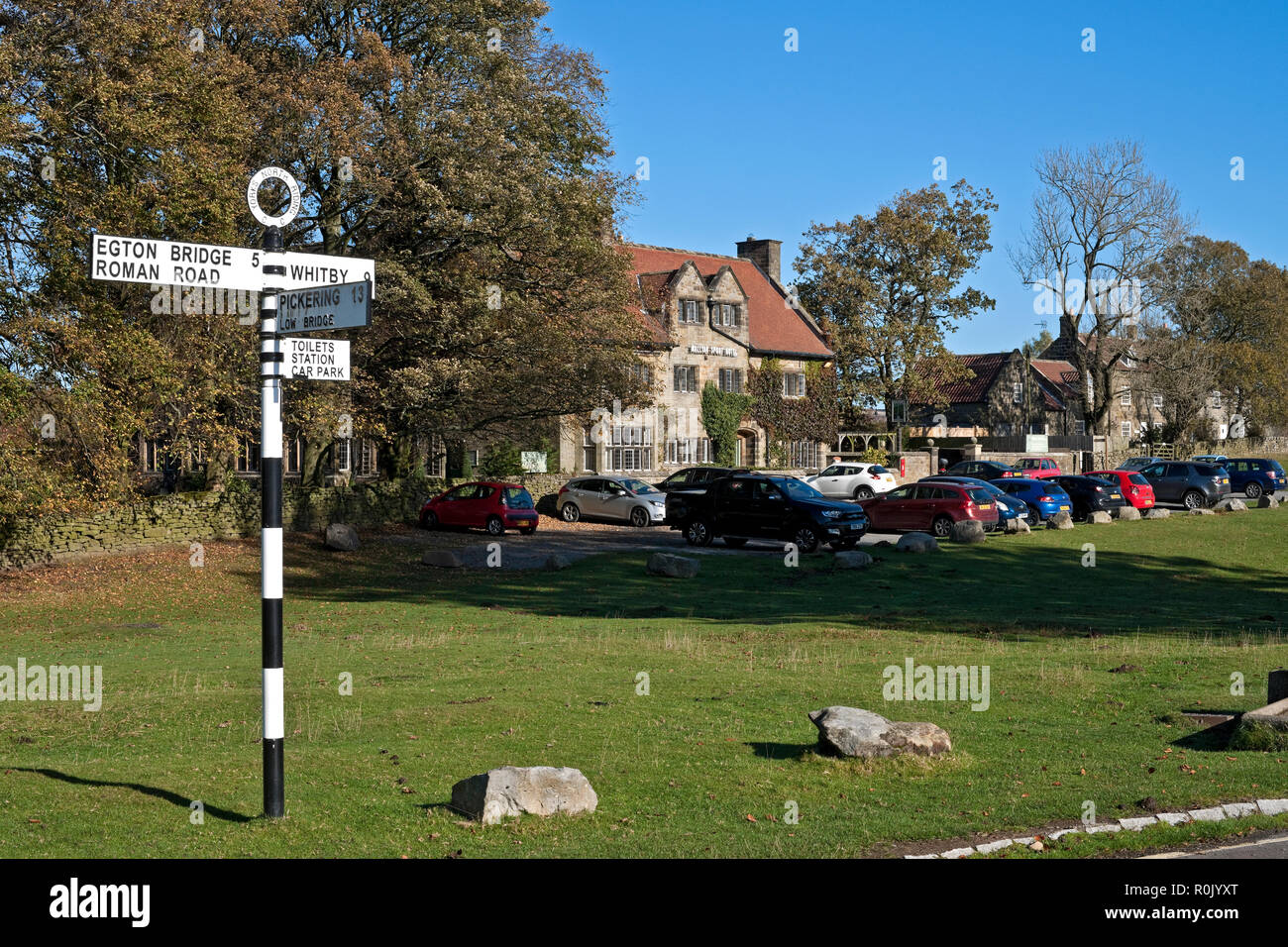 Signpost road sign outside the Mallyan Spout Hotel in autumn Goathland village North Yorkshire England UK United Kingdom GB Great Britain Stock Photo