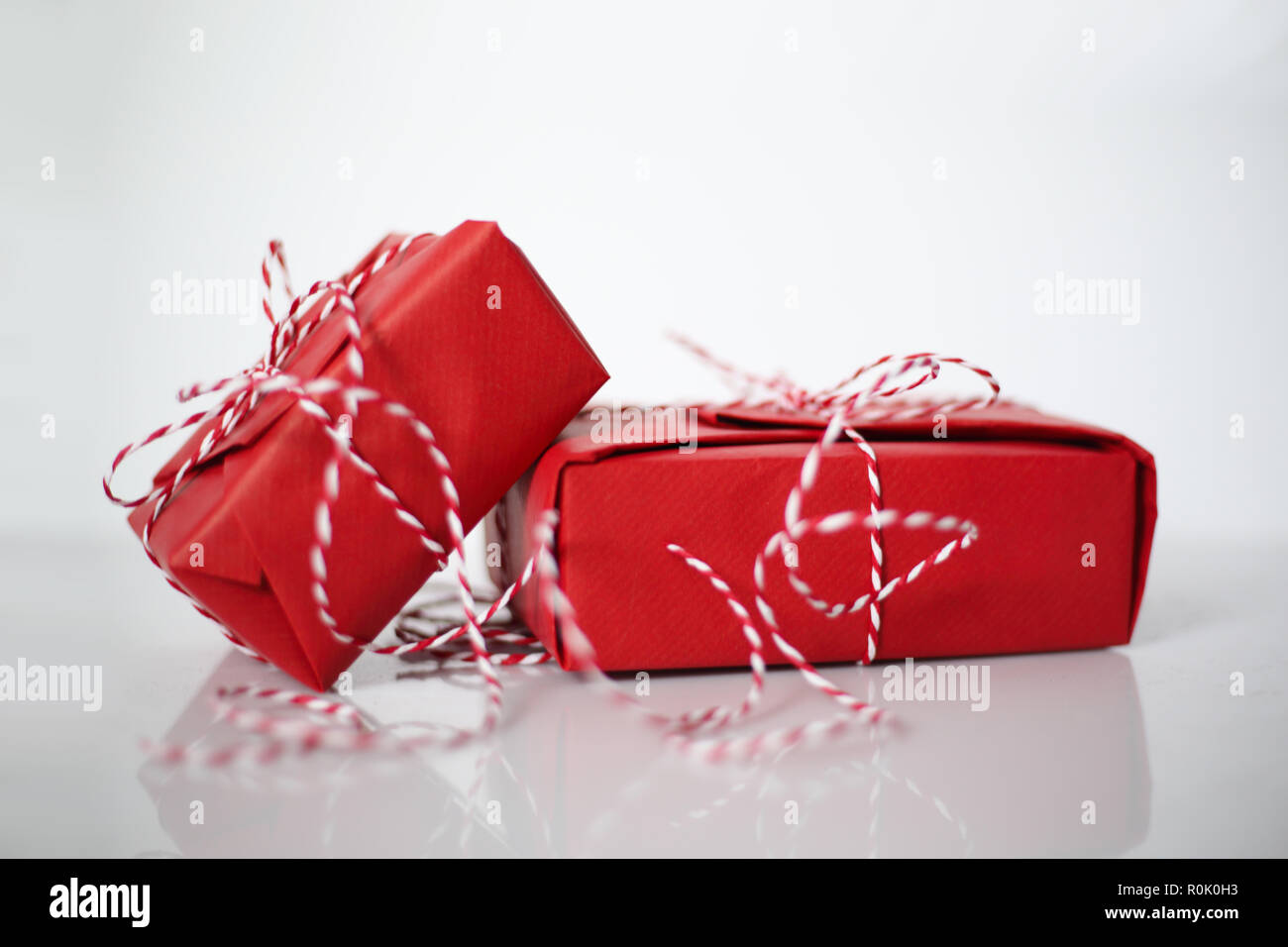 Christmas gift boxes wrapped in red paper and bow of dtriped rope on ...