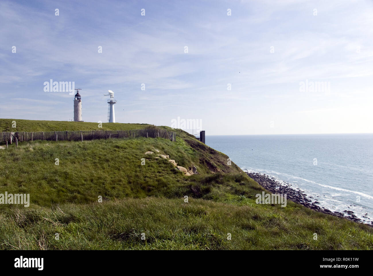 A lighthouse and radar tower stand atop Cap Gris Nez (grey nose cape), overlooking the English Channel, Cote d'Opale, Pas-de-Calais, France. Stock Photo