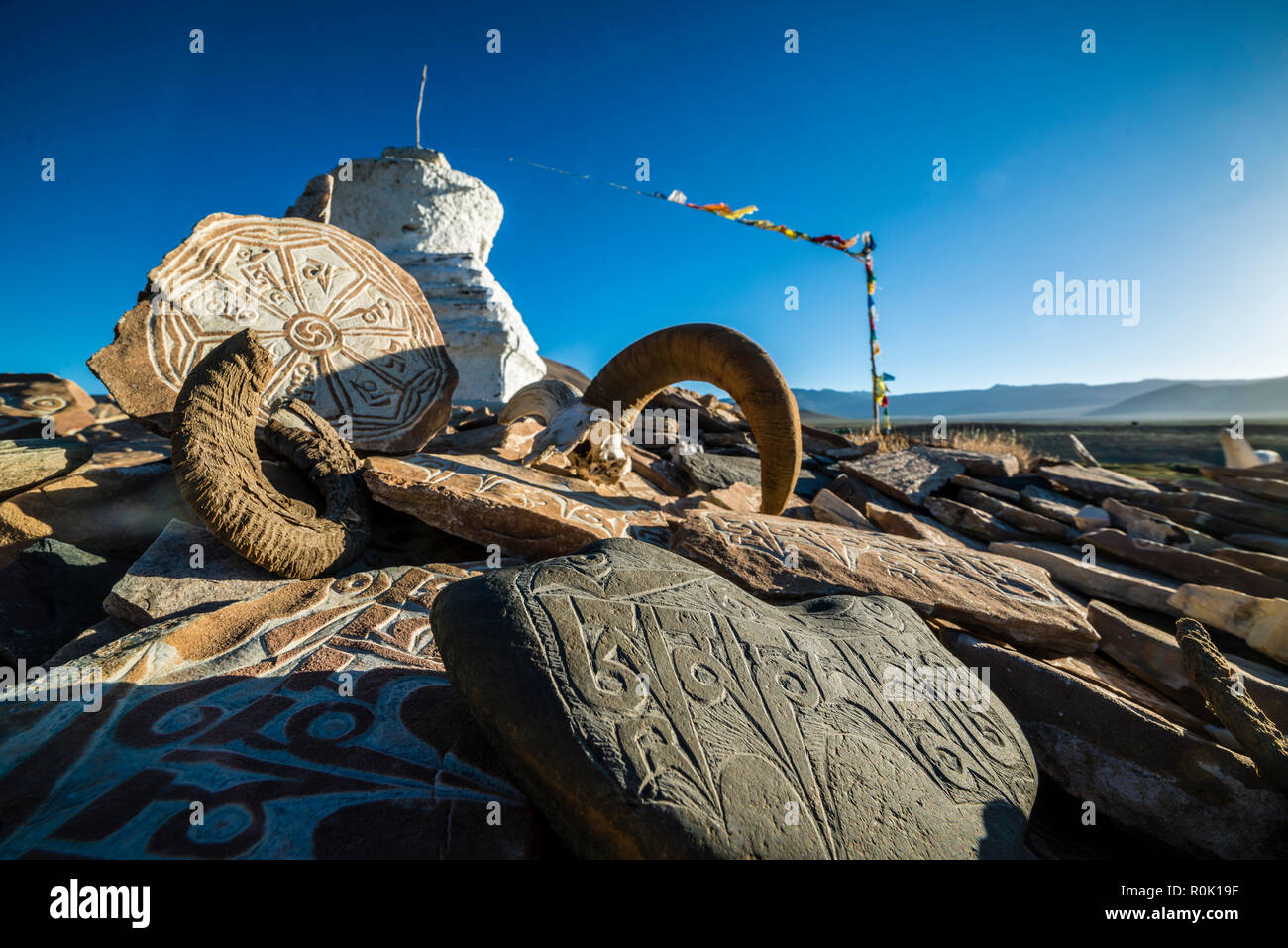 Mani walls, often placed along the roadsides or village entrances, are constructed by devotionally carved stones or animal skulls, mainly display the  Stock Photo