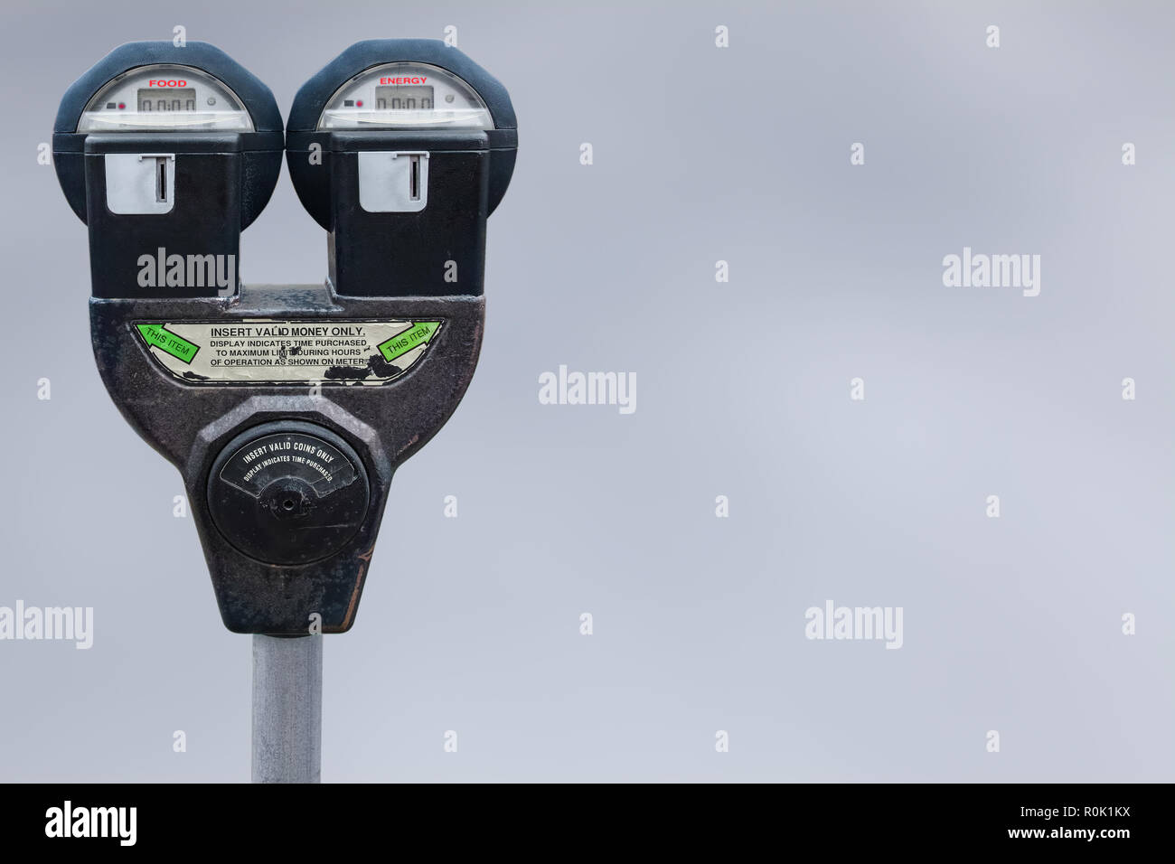 A double parking meter. On one side is marked FOOD, on the other, ENERGY. Copy-space Stock Photo
