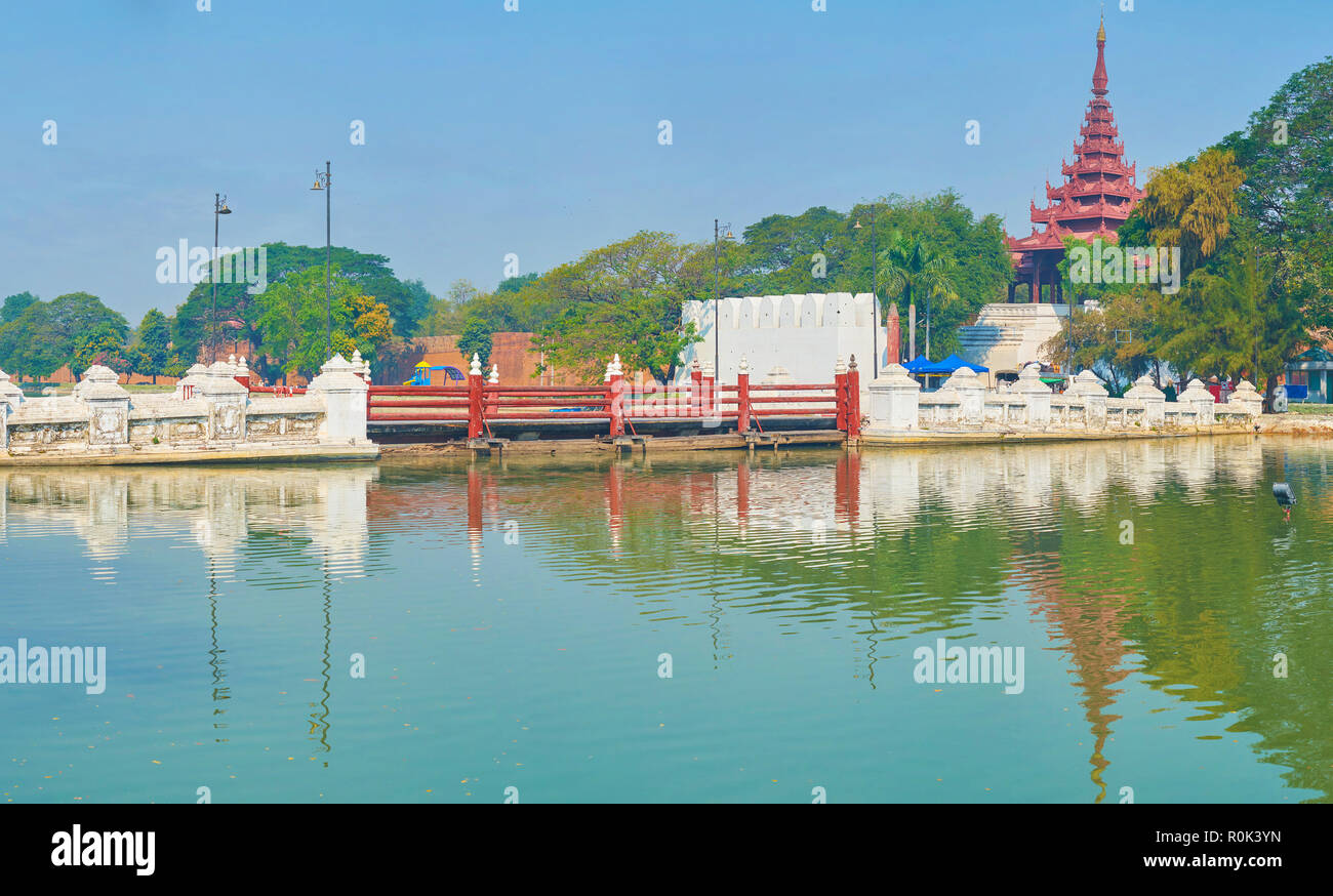 The stone bridge with wooden segment connects the South Gates of Royal Palace with the streets of Mandalay, Myanmar Stock Photo