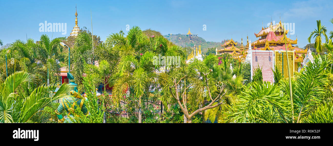 The roof of the shrines and the top of the main pagoda are only seen above the lush greenery of Kyauktawgyi Pagoda's garden, Mandalay, Myanmar Stock Photo