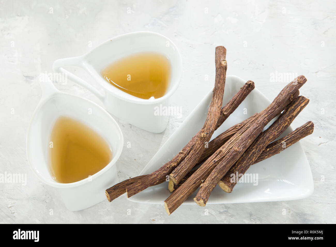Licorice tea and roots on white background Stock Photo