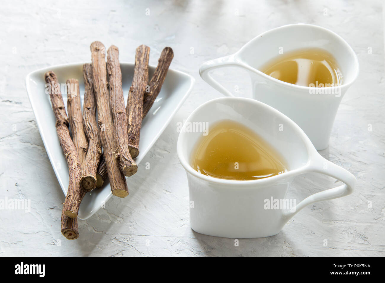 Licorice tea and roots on white background Stock Photo
