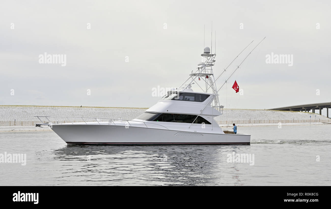 Commercial charter luxury fishing boat or yacht sailing through East Pass, in Destin Florida USA, heading for Harbor Walk Marina. Stock Photo