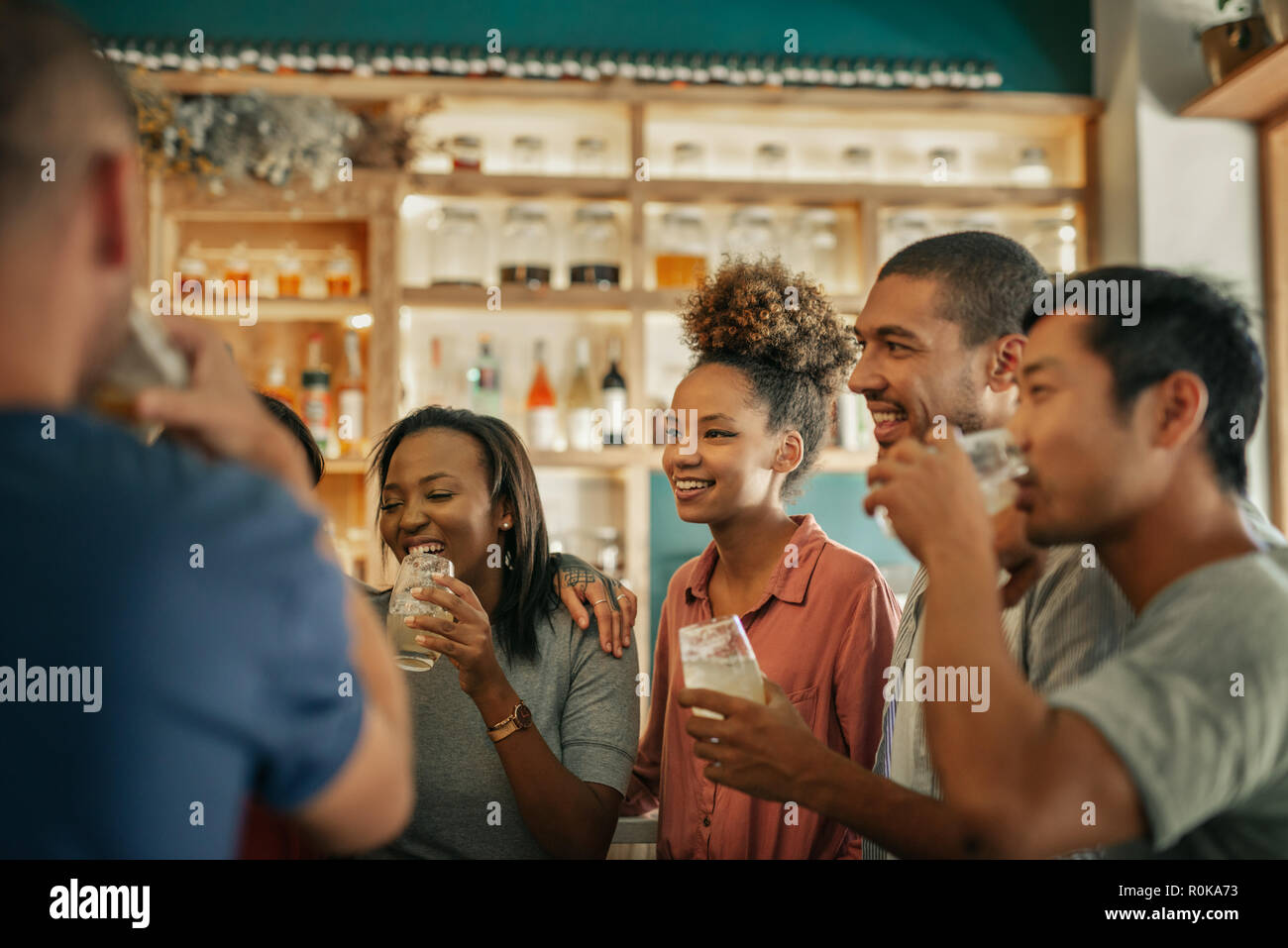 Diverse young friends hanging out together in a bar  Stock Photo