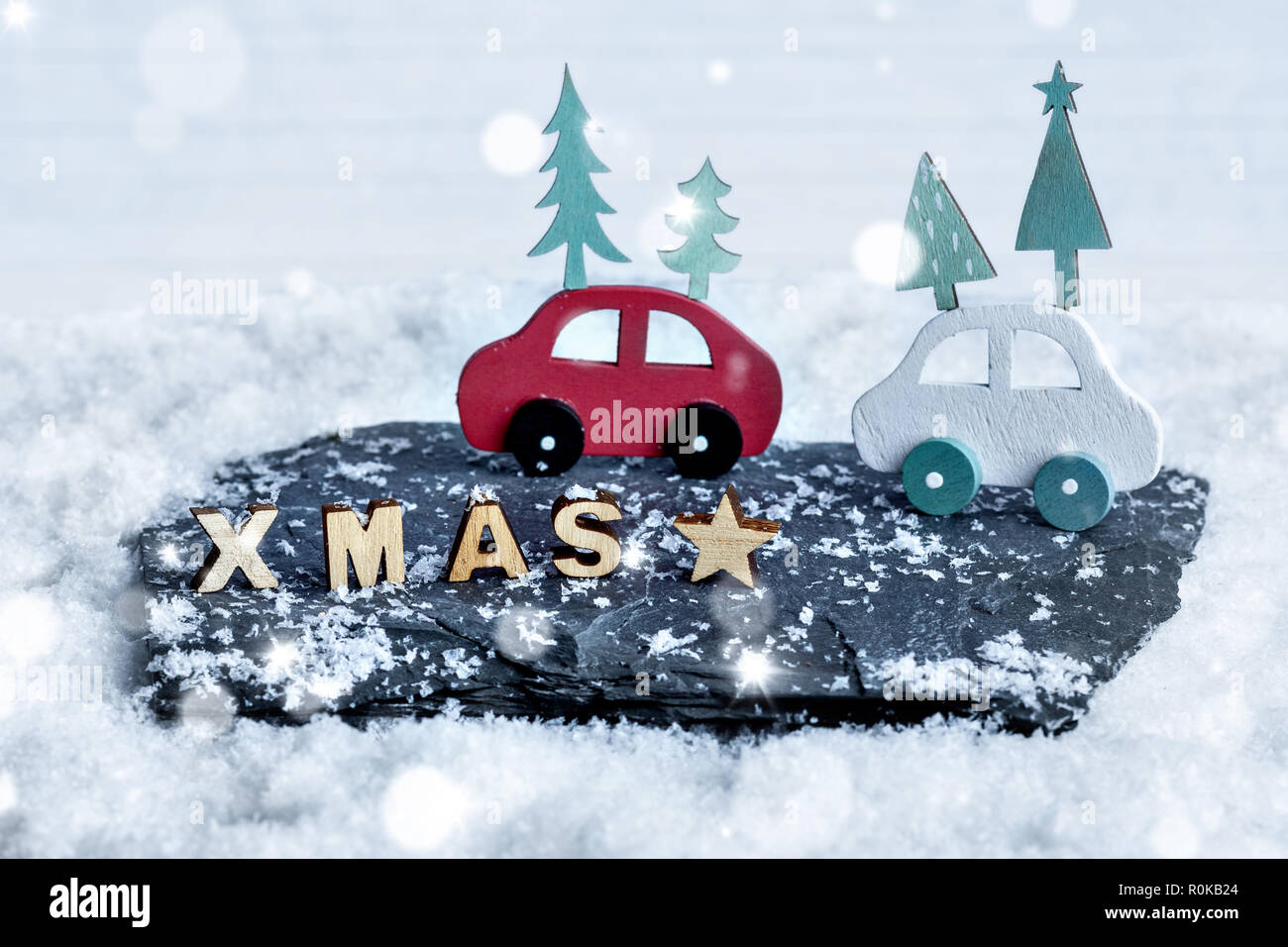 Christmas decoration of wooden XMAS letters and wooden cars in a snow scene Stock Photo