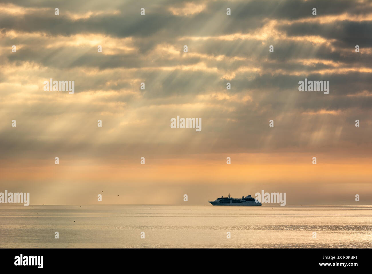Silhouette of Ferry in Shafts of Morning Light on Dublin Bay in Ireland Stock Photo