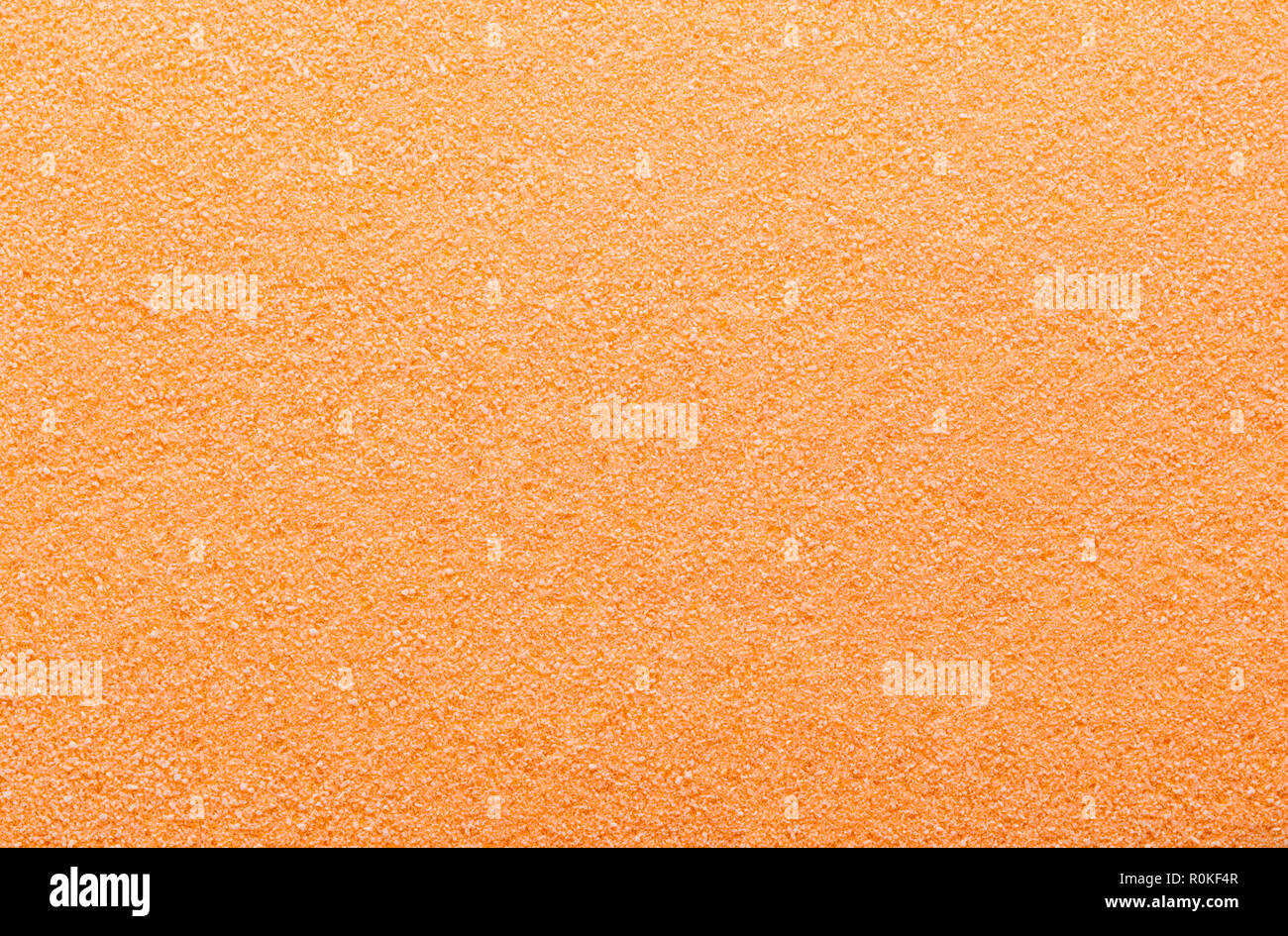 Flat Pile of Orange Sugar Grain Textured Background. Stock Photo