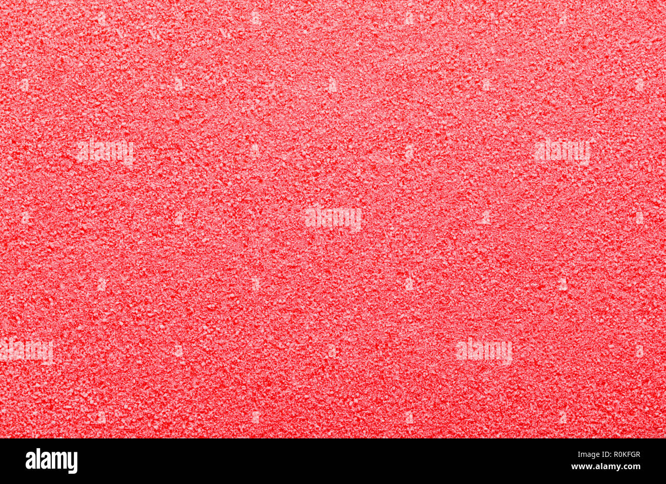 Flat Pile of Red Sugar Grain Textured Background. Stock Photo