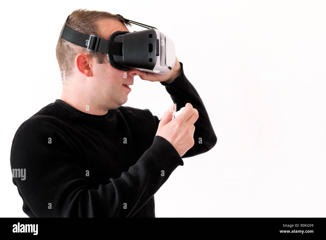 Handsome man wearing and playing virtual reality on isolated white background. Boy action in virtual reality helmet. VR glasses. VR Box, VR headset. Stock Photo