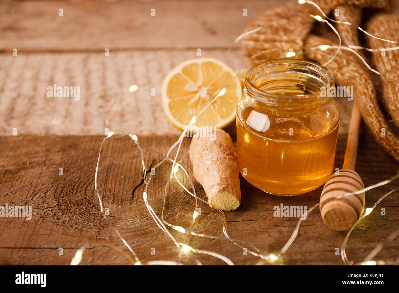 Composition with honey, lemon, ginger root as natural cold remedies on wooden background, winter holiday cozy home concept Stock Photo