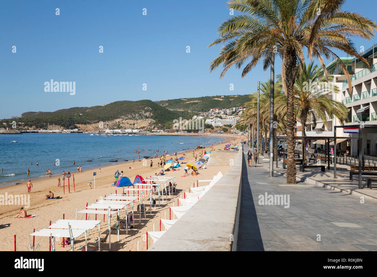 View along promenade and beach on sunny summer morning, Sesimbra, Setubal district, Lisbon region, Portugal Stock Photo