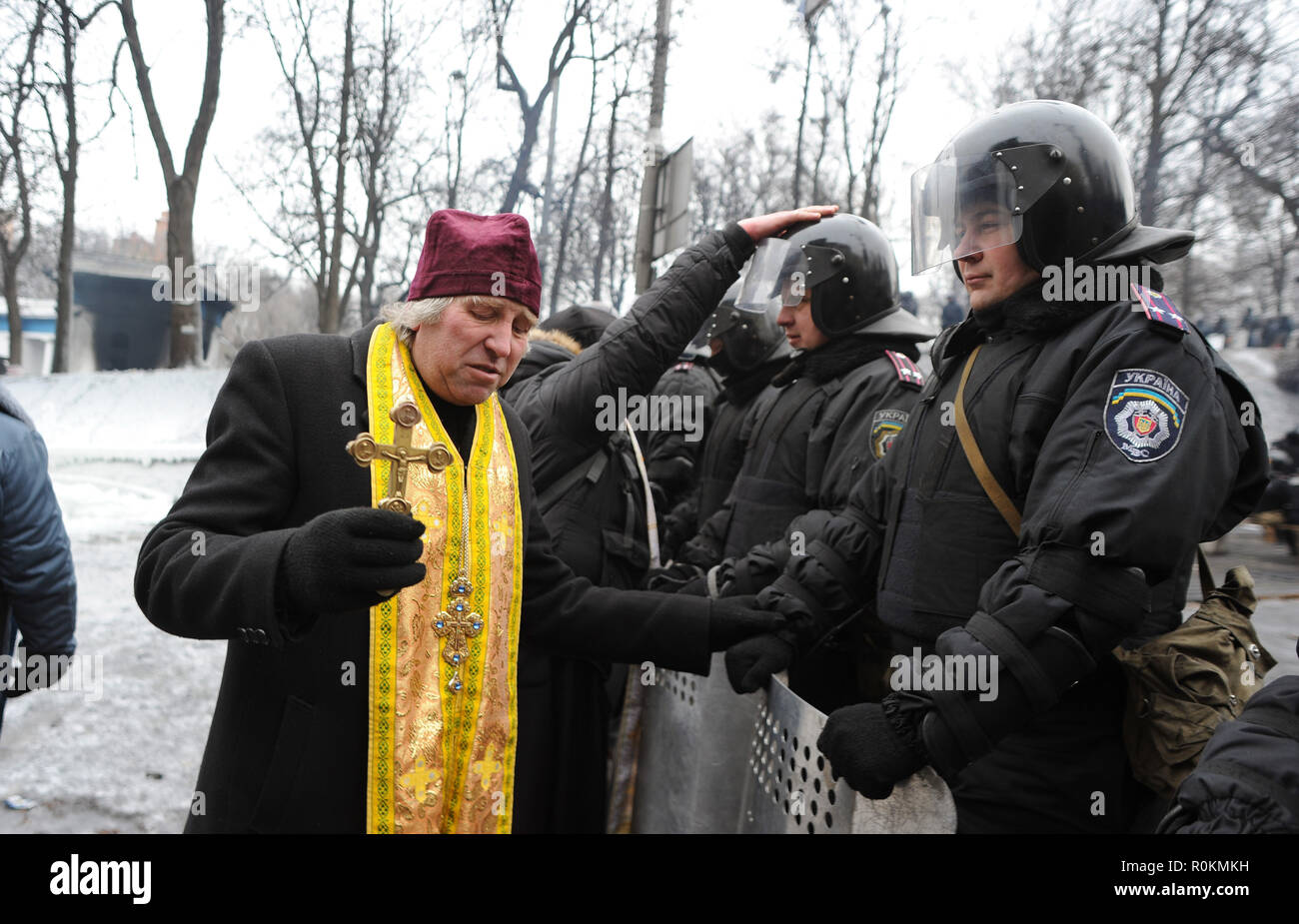 January 28, 2014 - Kiev, Ukraine: An orthodox priest confront riot police in Kiev, imploring the officers not to hurt people near the barricades close to Maidan. Un pretre orthodoxe preche la non-violence, auprs de policiers anti-emeute sur la rue Hroushevskoho, une rue herissee de barricades pres de place de l'Independance de Kiev, connue comme le Maidan. *** FRANCE OUT / NO SALES TO FRENCH MEDIA *** Stock Photo