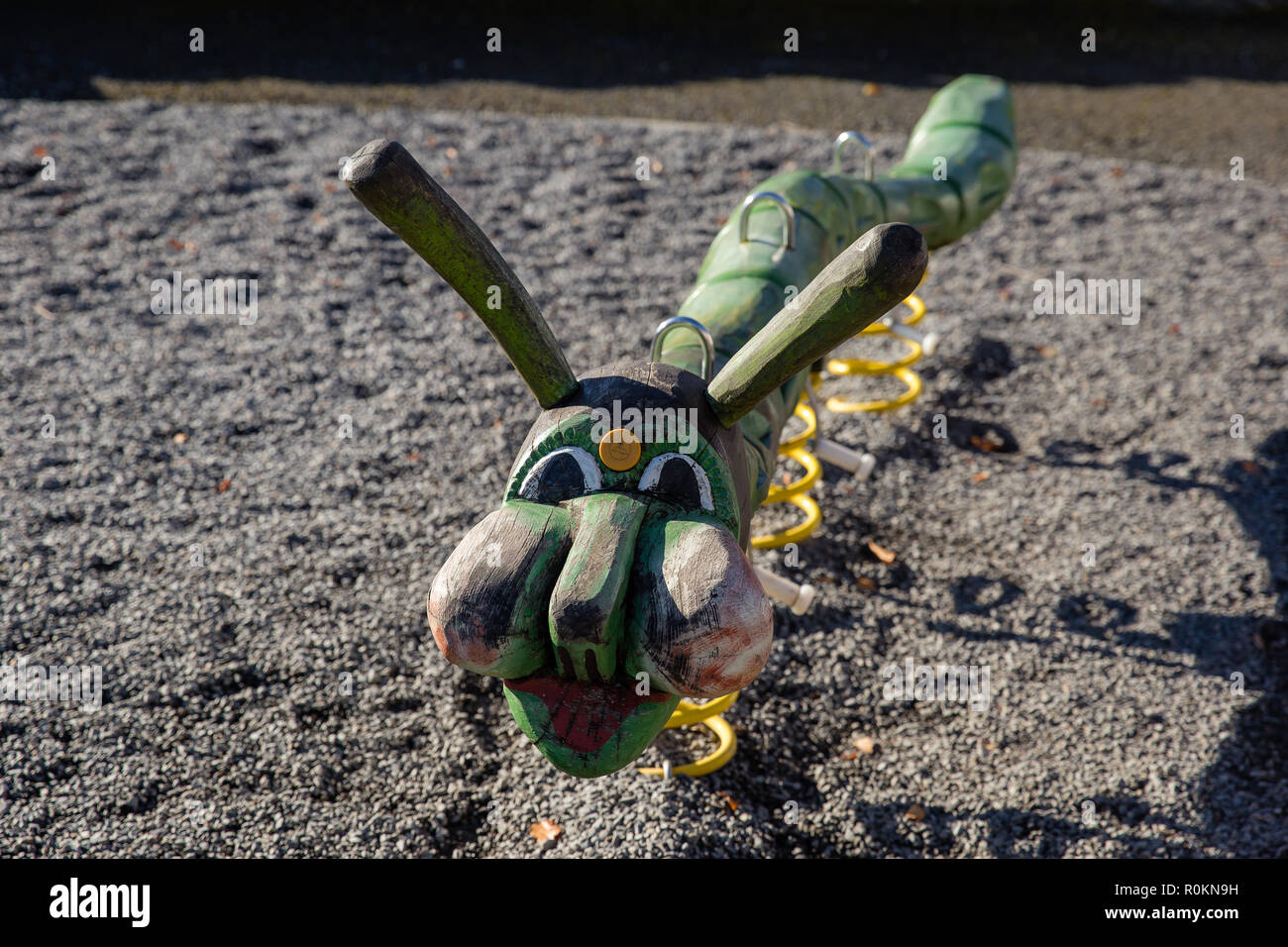 Playground equipment for children to play on - wooden caterpillar on springs. Stock Photo