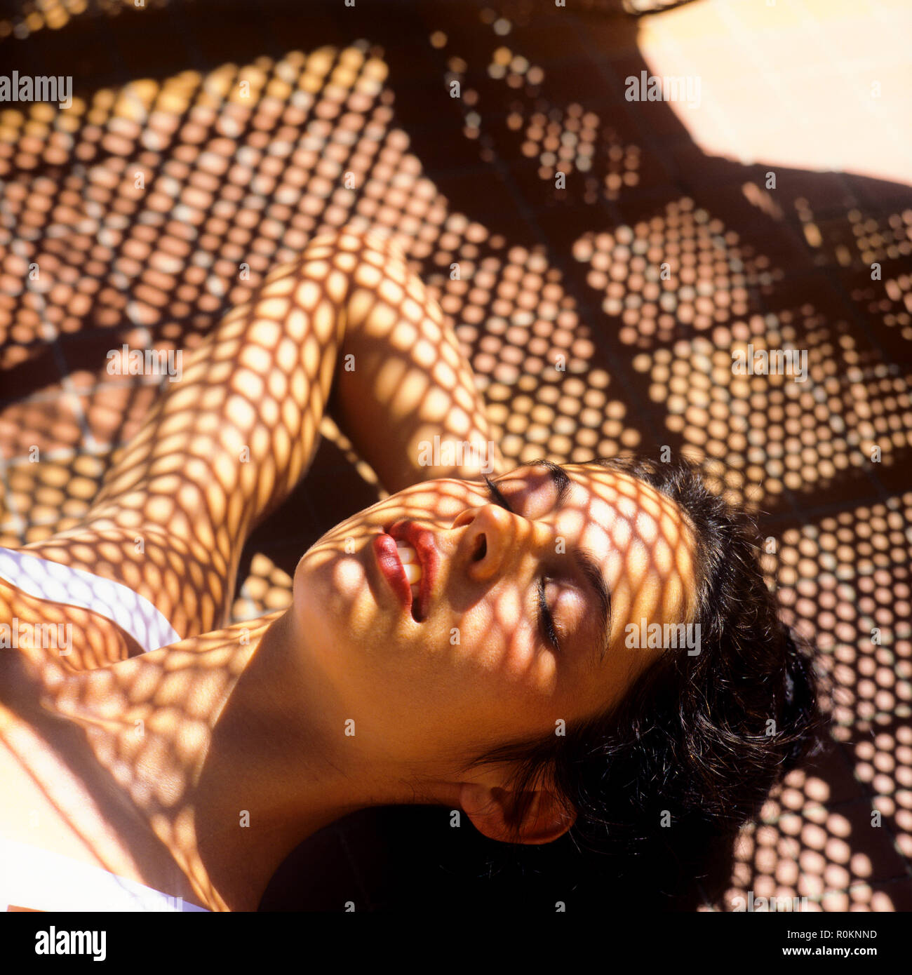 Sleeping young woman portrait, wickerwork shadow pattern, Guadeloupe, French West Indies, Stock Photo