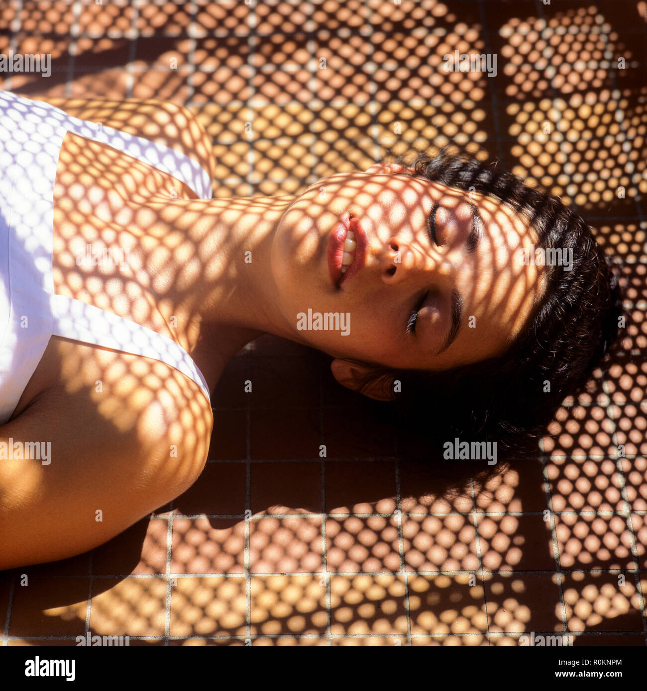 Sleeping young woman portrait, wickerwork stripes shadow pattern, Guadeloupe, French West Indies, Stock Photo