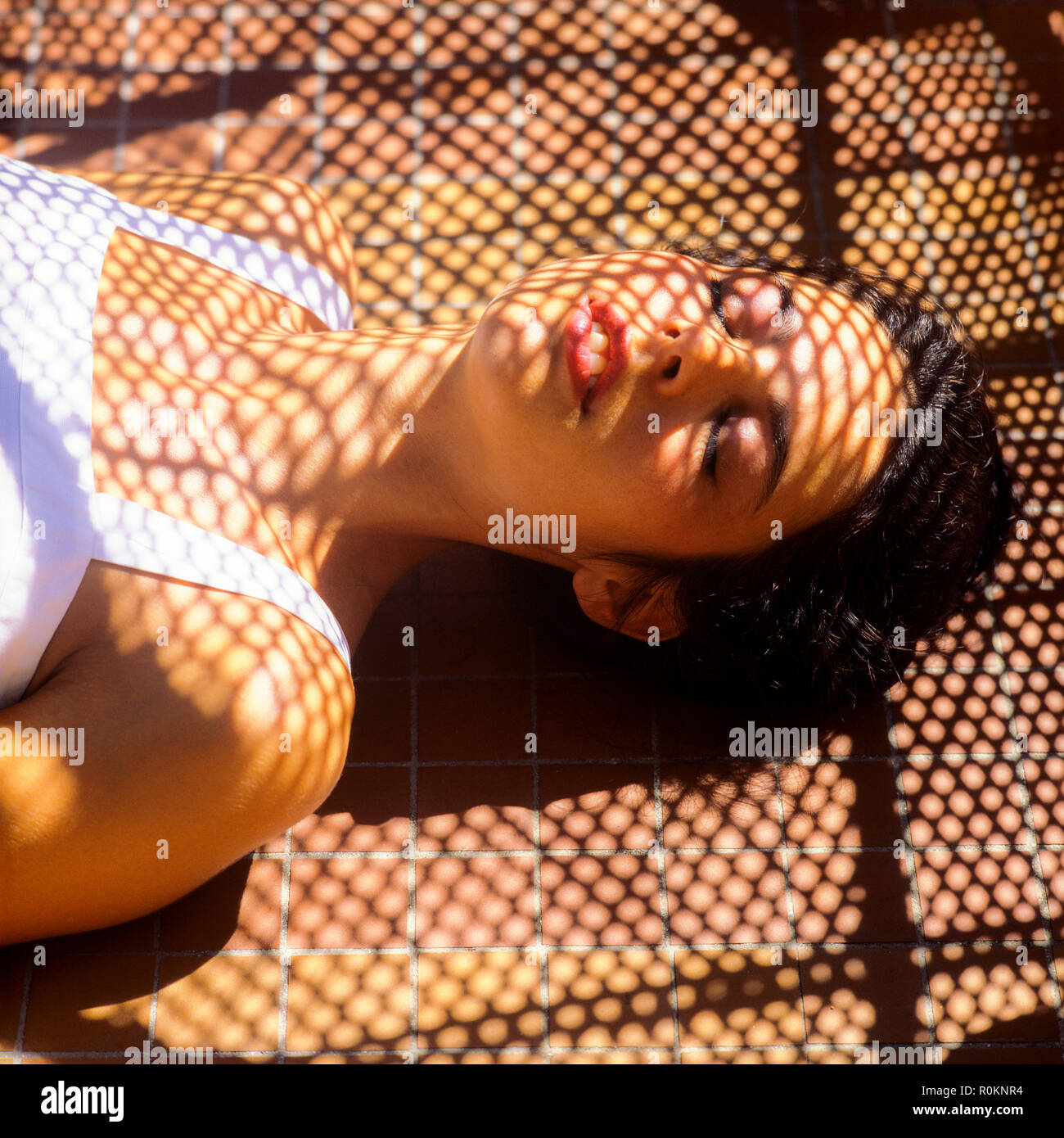 Sleeping young woman portrait, wickerwork shadow pattern, Guadeloupe, French West Indies, Stock Photo