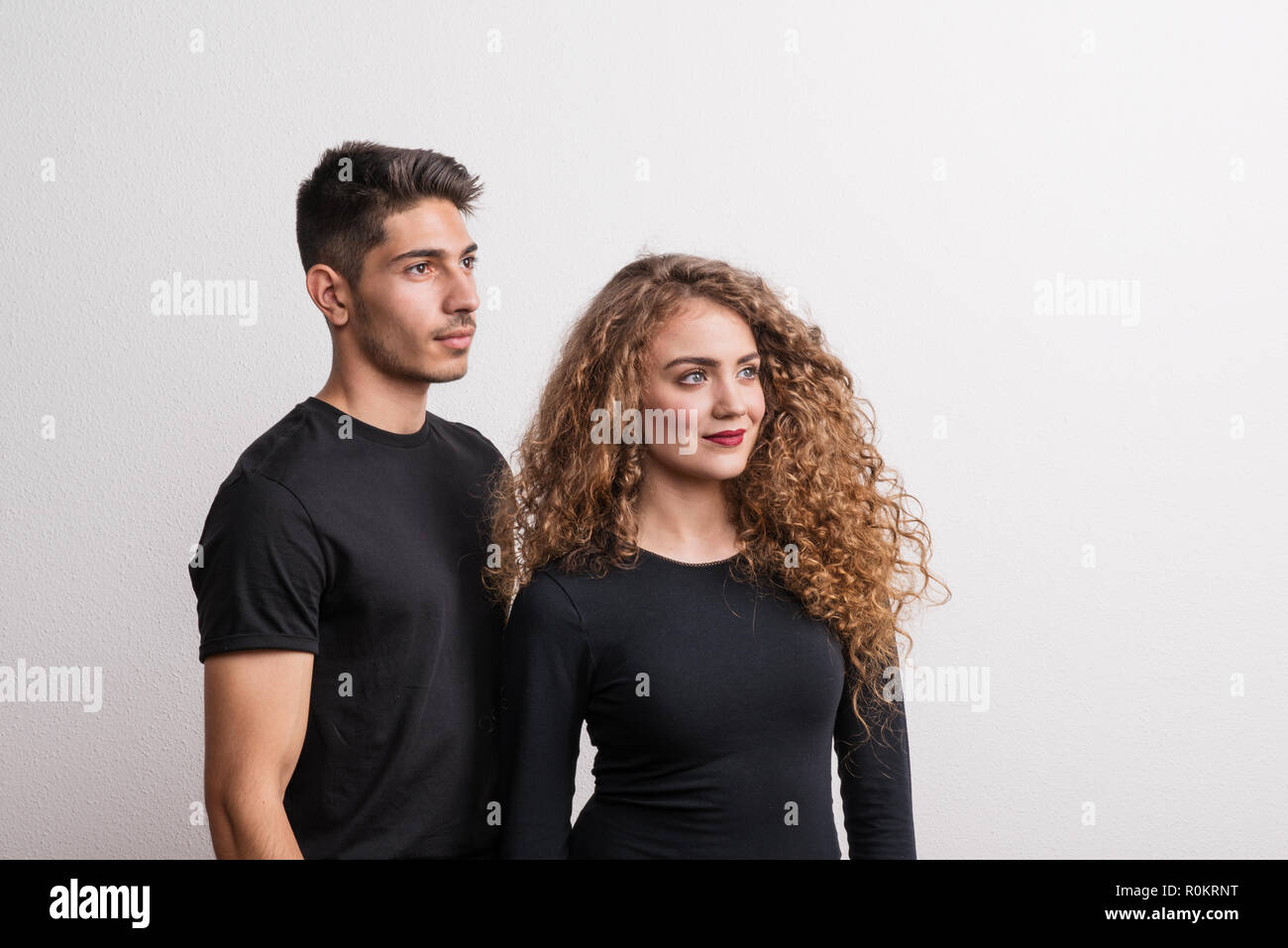 Portrait of a young couple standing in a studio, wearing black clothes. Stock Photo