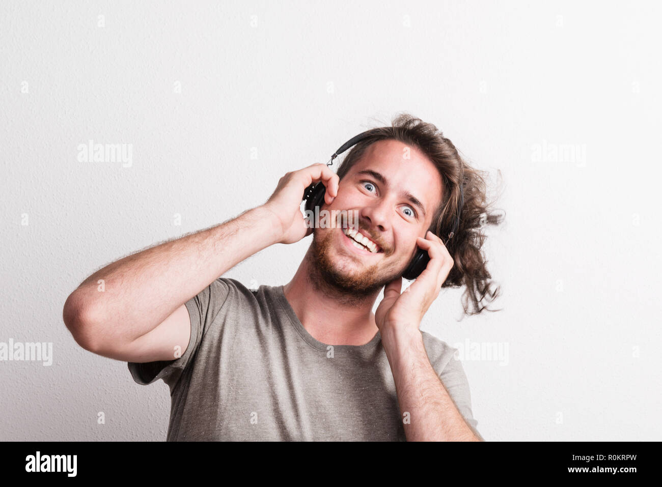 Portrait of a joyful young man with headphones in a studio. Stock Photo