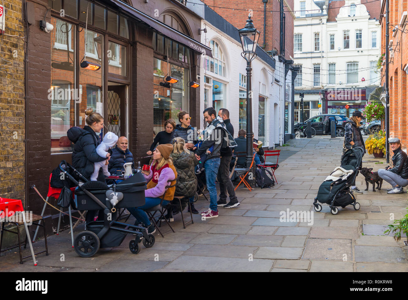 People socialising and enjoying refreshments in restaurant outdoor dining area, Perrin's Court, Hampstead, London, England, UK. Stock Photo
