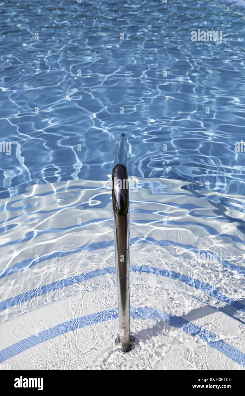 Railing at the pool, detail of a staircase in a summer pool, water and ...