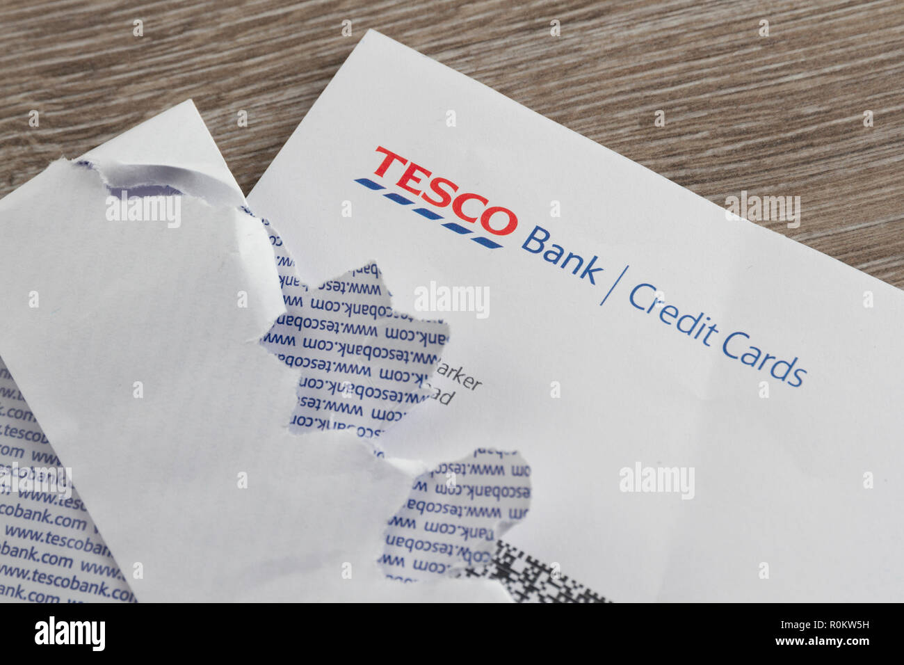 Tesco Bank Credit Card statement on table with ripped open envelope. Stock Photo