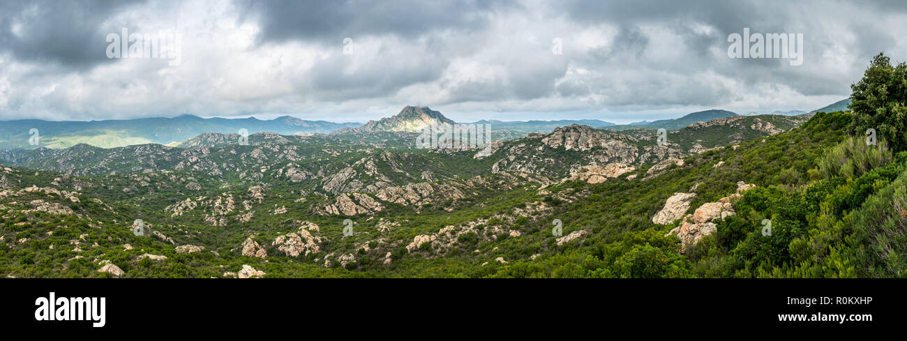 Panoramic view of Monte Genova in the Desert des Agriates in the north of Corsica. The 421m high peak is pictured under a dramatic grey cloudy sky. Stock Photo