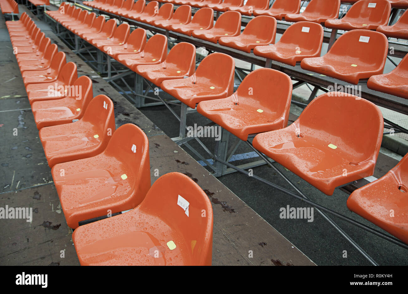 Wet red tiered rows, detail of seats in a soccer, sport