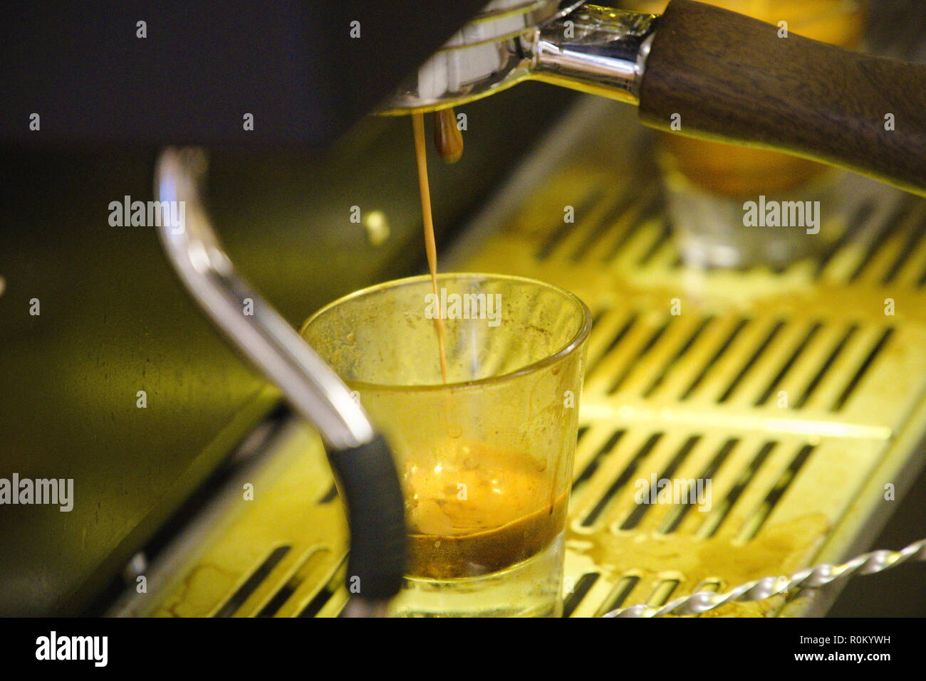 A shot of an espresso machine pouring shots of espresso into a glass