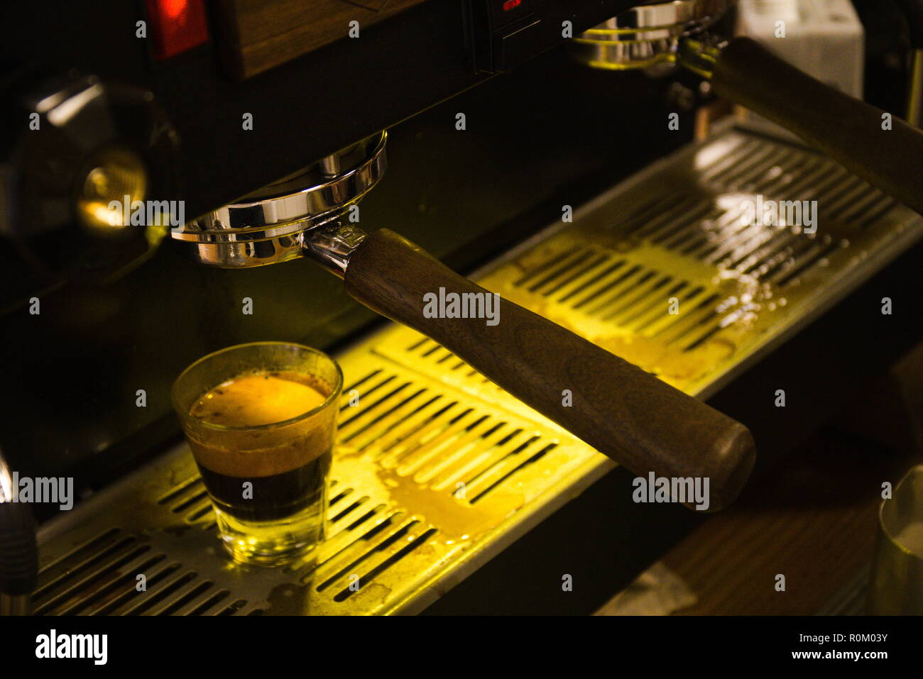 A shot of an espresso machine pouring shots of espresso into a glass