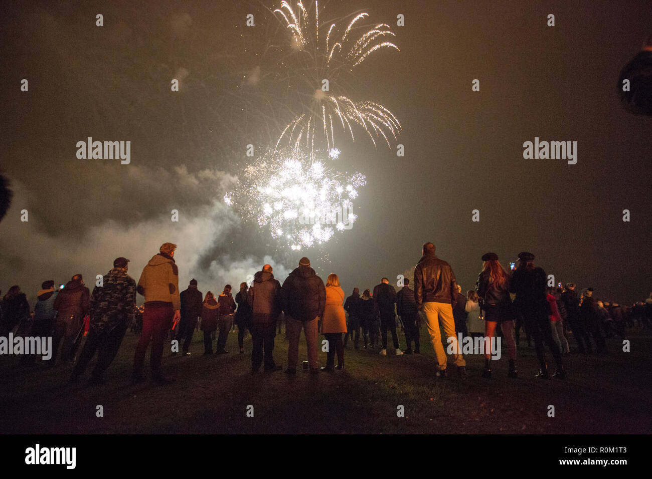 People looking at fireworks while gathering to celebrate the Bonfire and firework display in Roundhay Park, Leeds. Stock Photo
