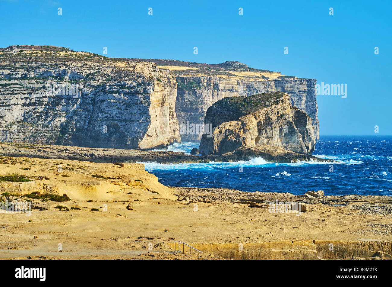 The tall cliffs and beautiful Fungus Rock (General's Rock) on the coast of Dwejra Bay, famous for Azure Window site and Dwejra Inland Sea, San Lawrenz Stock Photo