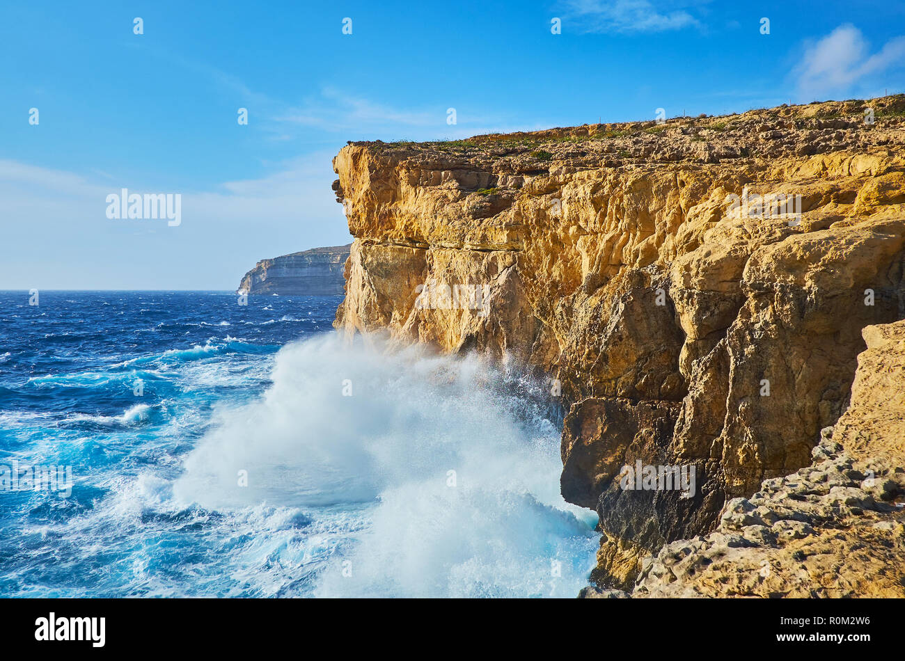 Watch the foaming waves of the storm from the rocky cliff of San Lawrenz coast at former Azure Window site, Gozo Island, Malta. Stock Photo