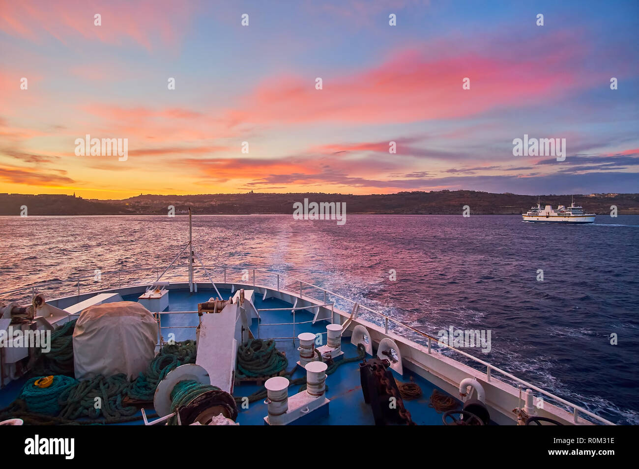 The view on ferry, floating to Gozo Island from Malta on twilight with bright fiery clouds in